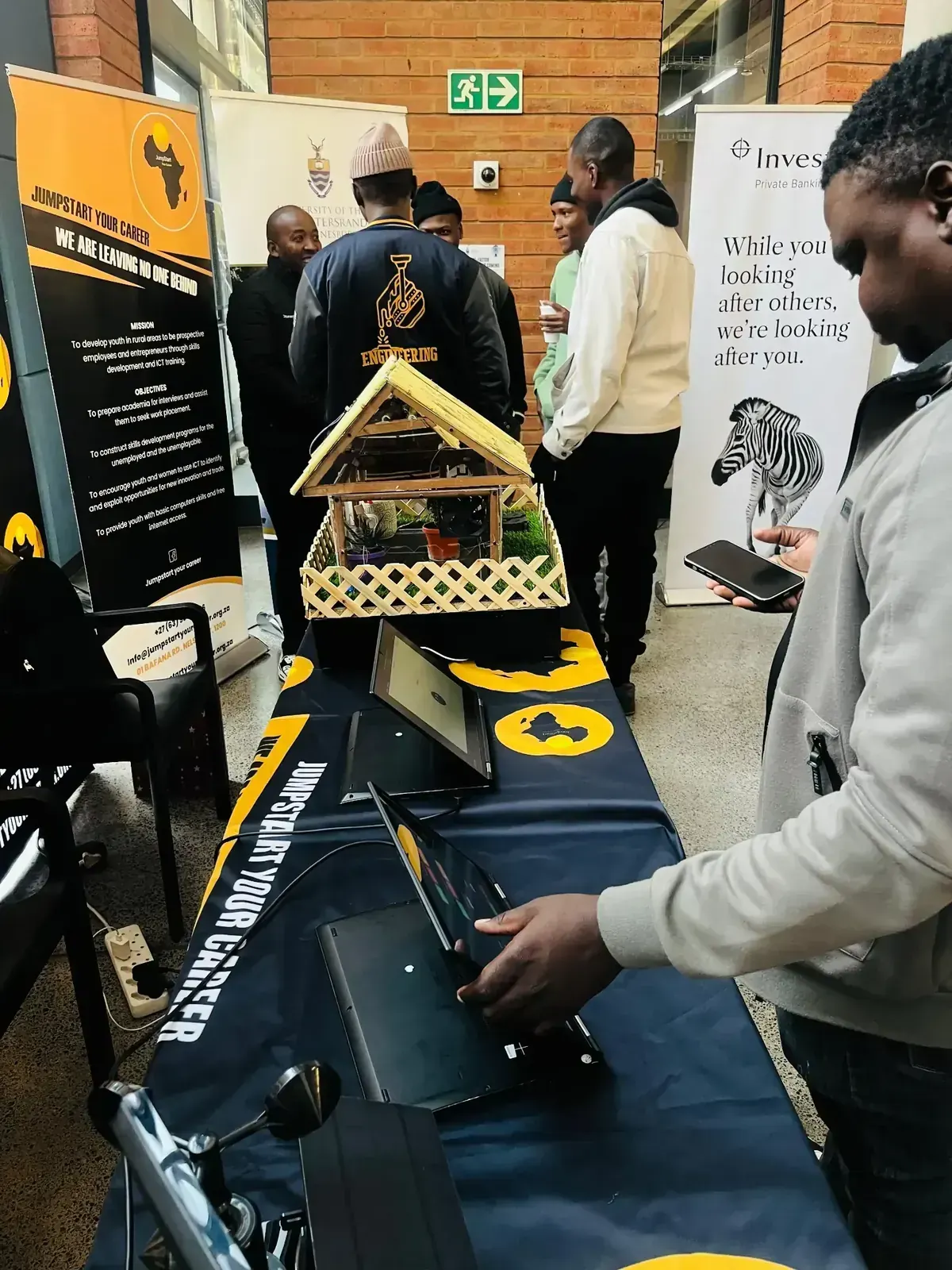 A JumpStart exhibition table with laptops and a smart model prototype on display.