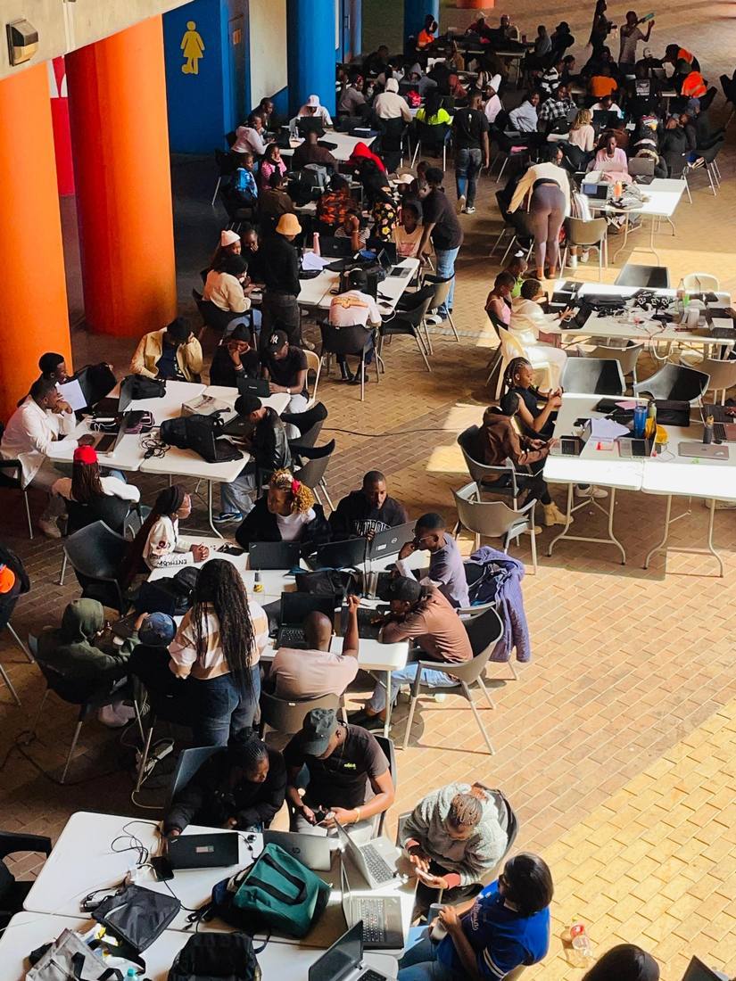 Rural youth and women working at tables inside the JumpStart innovation hub.
